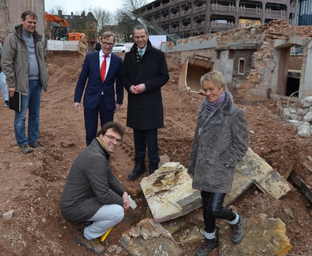 Auf der Baustelle: Bürgermeister Dr. Maximilian Ingenthron (3.v.l.), Vorstandsvorsitzender der VR-Bank Südpfalz, Christoph Ochs (2.v.l.), Architekt Jürgen Sebastian (1.v.l.), Stadtdenkmalpfleger Jörg Seitz (vorne links) und Dr. Andrea Zeeb-Lanz von der Direktion Landesarchäologie (vorne rechts). Foto: stadt-landau