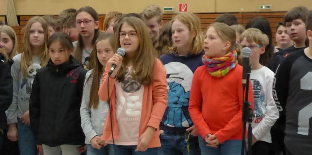 Fünftklässer weisen mit „An Tagen wie diesen“ auf das besondere Ereignis hin.