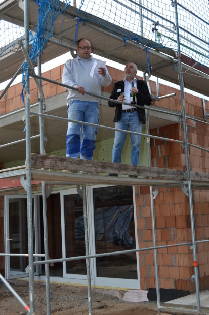 Dachdecker Thomas Styner (links) hält den Richtspruch, der zum Schutze des Hauses und deren Bewohner ausgesprochen wird. Foto: stadt-landau