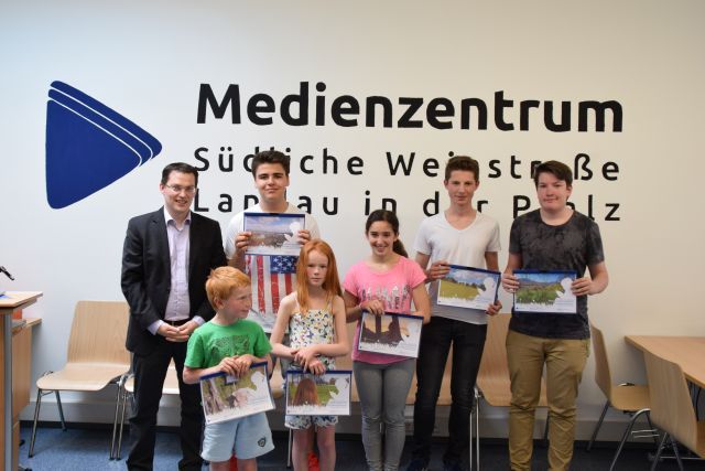 Einige der jugendlichen Teilnehmer des Fotowettbewerbs "Mein Lieblingsplatz" präsentieren stolz ihre Fotos. Und Joachim Dieterich (links), der Leiter des Medienzentrums, freut sich mit ihnen. Foto: red
