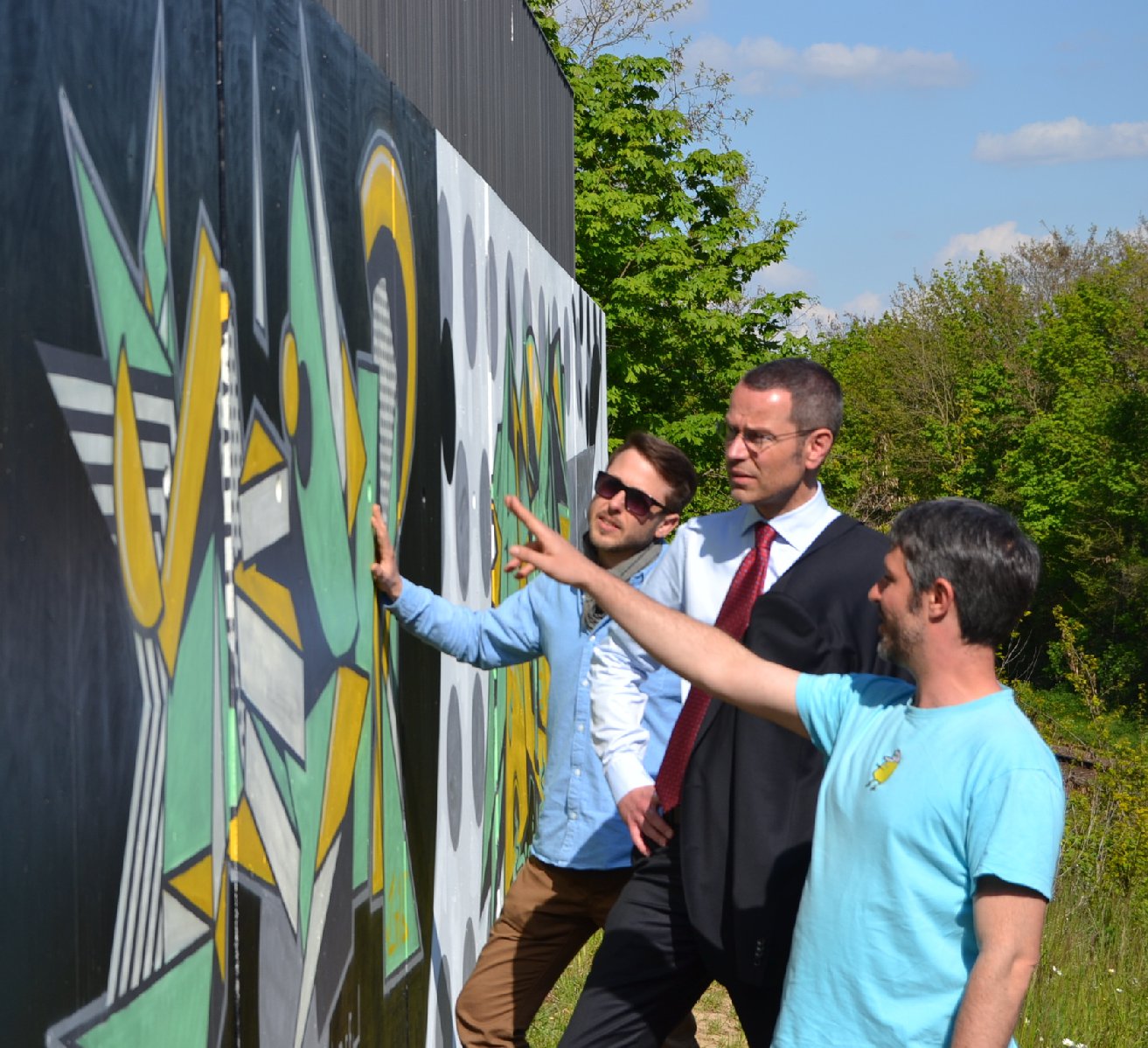 Till Heim, Bürgermeister Dr. Maximilian Ingenthron und Uli Roth (v.r.n.l.) präsentieren die neuen Graffitis an der Brücke Süd. Foto: stadt-landau