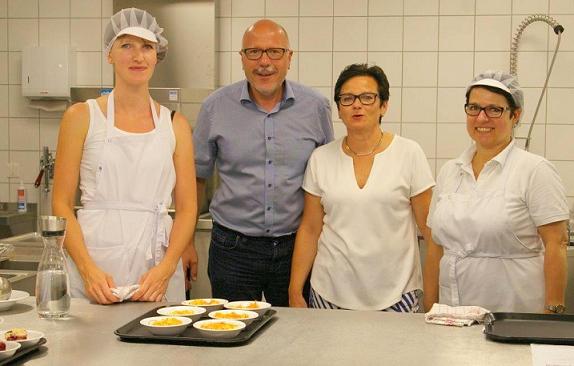 Bürgermeister Poß und Schulleiterin Lehr zusammen mit den beiden Wirtschaftskräften Ekatherina Schwiegk (links) und Irena Bednarek (rechts) bei der Essenausgabe.