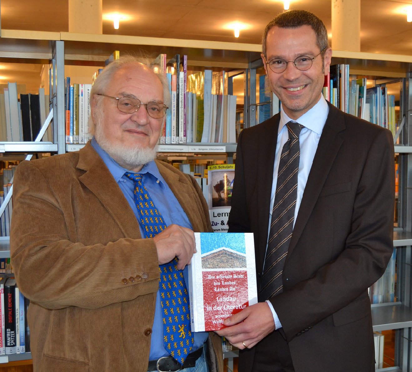 Wolfgang Diehl (links) überreicht Bürgermeister Ingenthron sein neuestes Werk. Foto: stadt-landau