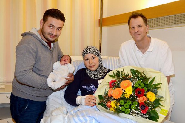 Oberarzt Dr. Daniel Grube überreicht im Namen des Vinzentius-Krankenhauses den Blumenstrauß an die glückliche Familie. Foto: Über Vinzentius-Krankenhaus 