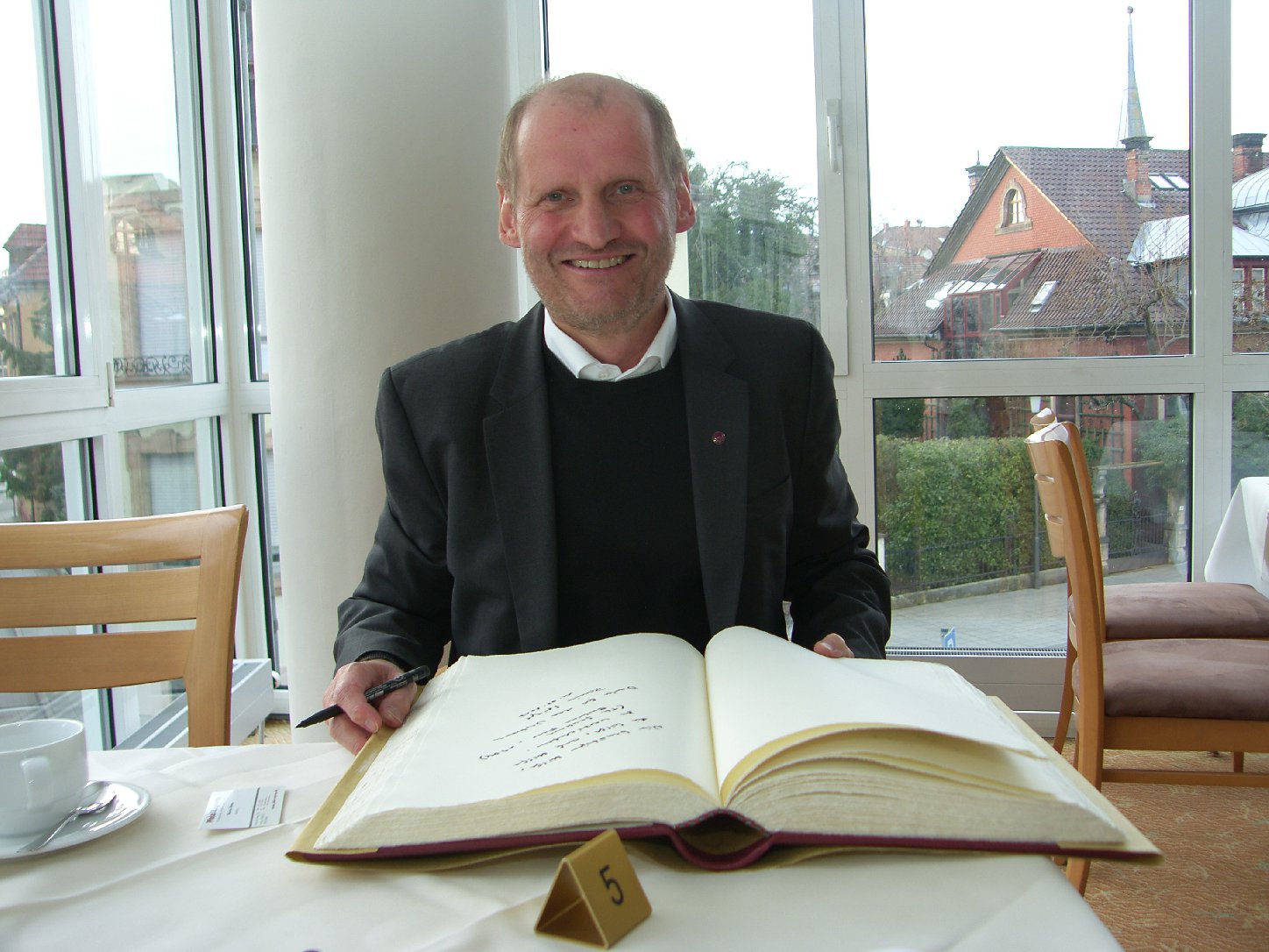 Monsignore Pirmin Spiegel schreibt ins Goldene Buch der Aktion Hilfe für Not. Foto: Pfalz-Express/Ahme