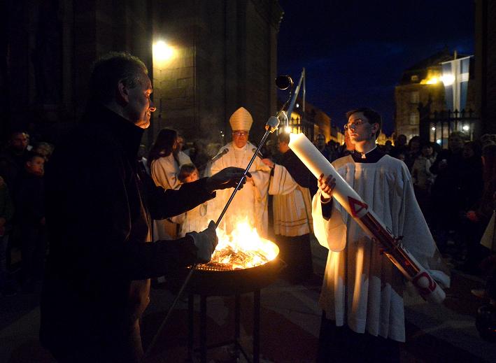 Die Osterkerze wird in der Osternacht am Osterfeuer in der Vorhalle entzündet und in den dunklen Dom getragen.