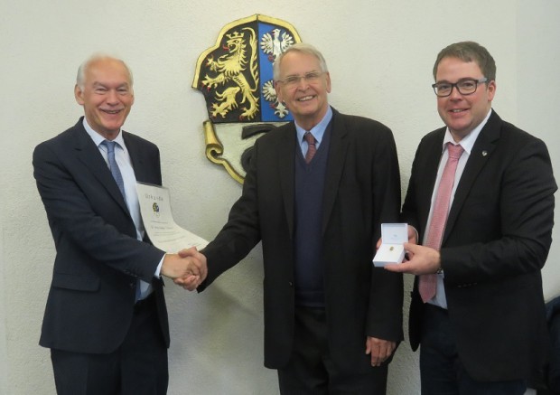 Dr. Hans-Dieter Drewitz (Mitte) freut sich über die von Bürgermeister Lorch (links) und Beigeordnetem überreichte Auszeichnung. Foto: red