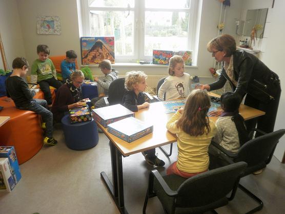Die Schüler aus Steinweiler sind mit Lehrerin Fuhrmann in der Ecke mit den Spielen „Die Leseratte“ und „Dobble“ beschäftigt, am Tisch spielt Rektorin Heppenheimer beim „Activity junior“ mit. Foto: lumi