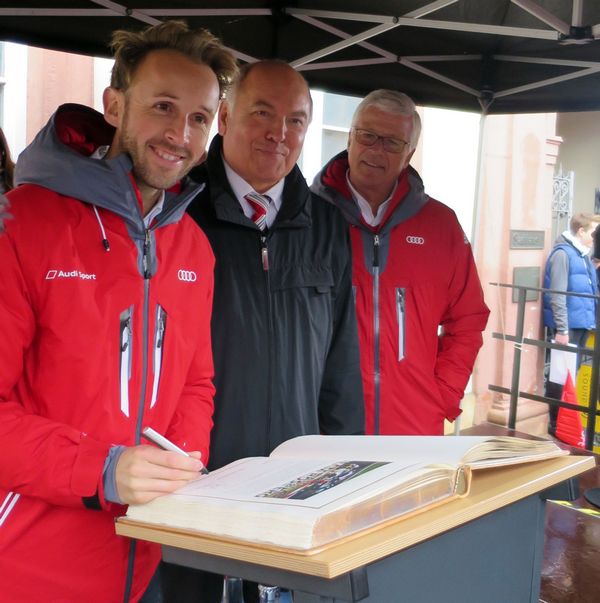 René Rast bei seinem ersten Eintrag in ein Goldenes Buch einer Stadt, daneben OB Löffler und Teamchef Arno Zensen. Foto: stadt-nw