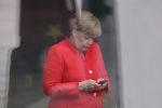 Bundeskanzlerin Angela Merkel schreibt eine Nachricht auf ihrem Handy