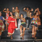 Tänzer und Sänger des UniZulu Choir in bunten Kleidern auf der Bühne