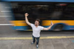 Junger Mann mit Handy in Siegerpose