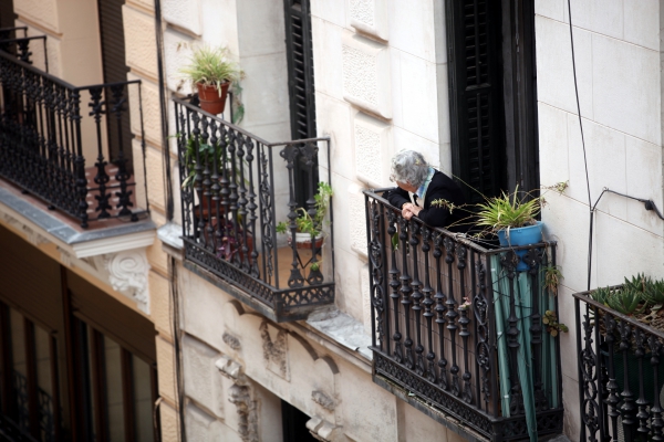 Seniorin schaut von einem Balkon