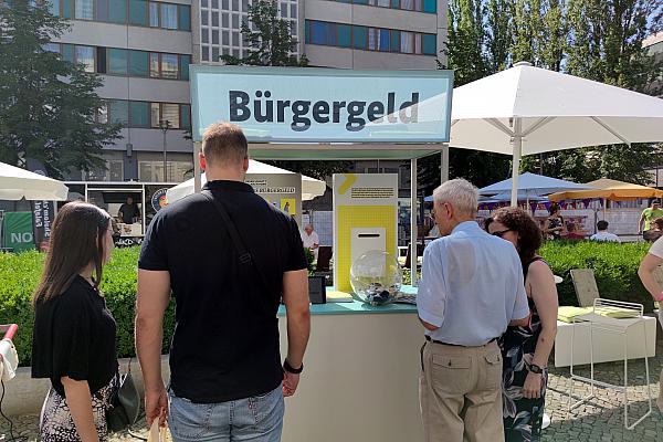 Passanten an einem Bürgergeld-Infostand