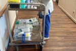 Medikamentenwagen in einem Krankenhausflur mit einer Krankenschwester